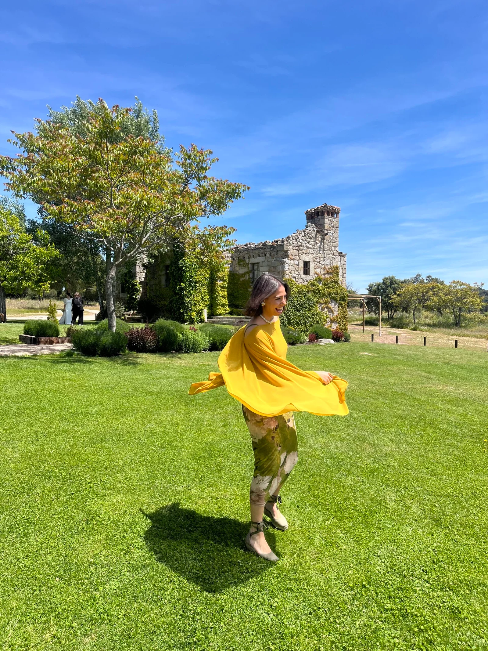 persona con vestido amarillo girando en un jardín